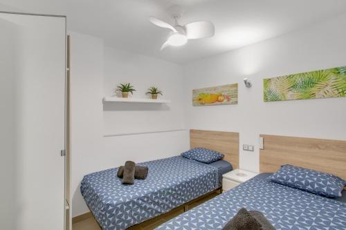 a room with two beds with blue sheets at El Nido de los Ángeles in Playa del Ingles