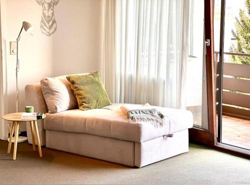 a living room with a couch in front of a window at Fewo Tannenduft - Freudenstadt in Freudenstadt