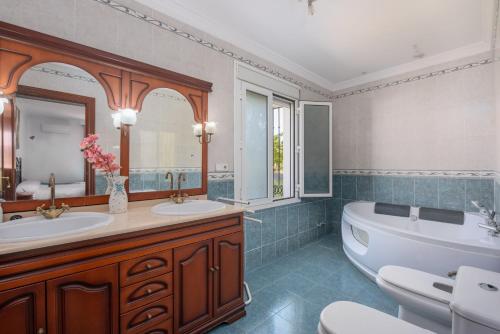 a bathroom with two sinks and a tub and a bath tub at Villa Minerva in Ronda