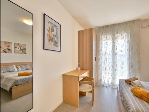 a bedroom with a bed and a desk and a mirror at New Casa Tiberio in Lazise