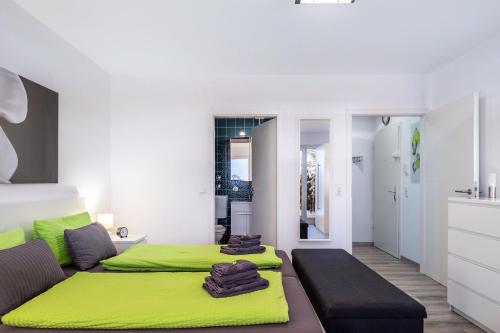 a bedroom with two beds and a green blanket at Schwarzwaldblick C App 2 mit Pool in Schönwald