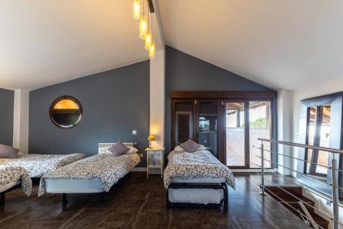 a bedroom with two beds and a mirror at Sierra Norte Madrid in El Berrueco