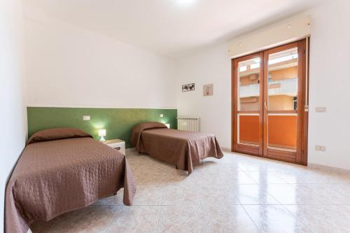 a bedroom with two beds and a door in it at Colombo Rooms in Sestu