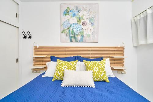 a bedroom with a blue bed with yellow and white pillows at Brisa Marina in Almuñécar