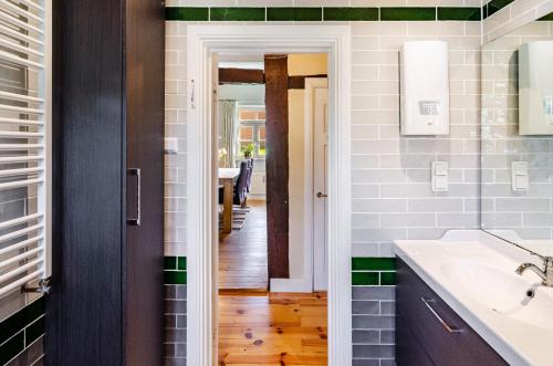 a bathroom with green and white tiles and a sink at Villa Gottstreu in Gottstreu
