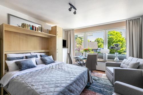 a bedroom with a large bed and a dining room at Ferienwohnung mit Badestrand in Glücksburg