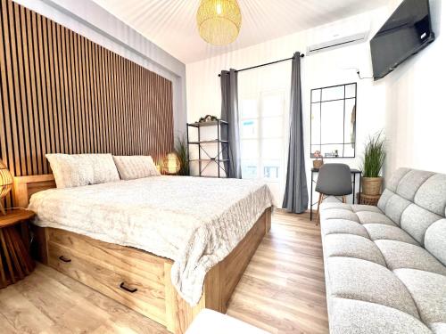a bedroom with a large bed and a couch at aeolian blu 5 in Parikia