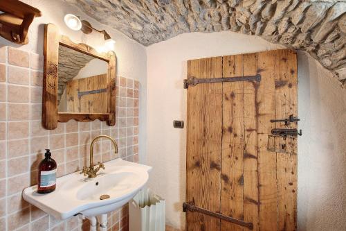 a bathroom with a sink and a wooden door at La Maison de Karen The Deer House in Gignod
