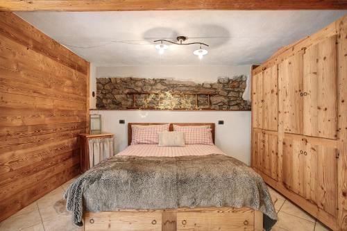 a bedroom with a bed and a stone wall at La Maison de Karen The Deer House in Gignod