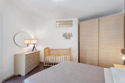 a bedroom with a crib and a dresser at Vecchia Scala in Germignaga