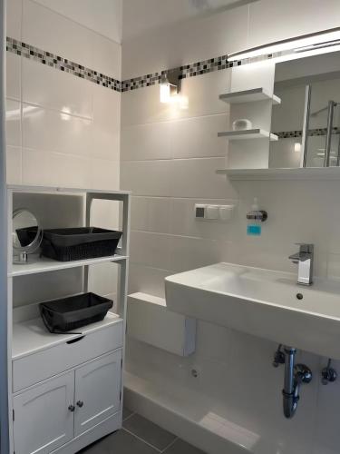 a white bathroom with a sink and a mirror at Ferienwohnung deluxe in Goslar