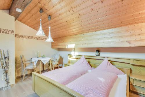 a bed in a room with a wooden ceiling at Beim Kreuzfelder Zwiesel in Inzell