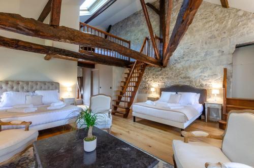 a large room with two beds and a staircase at Château De La Rive in Cruet