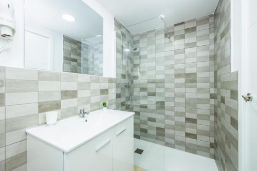 a white bathroom with a sink and a shower at Gran Sol Family 2 in Felanitx