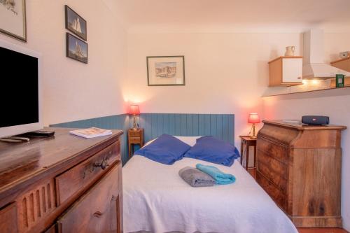a small bedroom with a bed and a flat screen tv at Studio Le Val de Pons Ramatuelle in Ramatuelle
