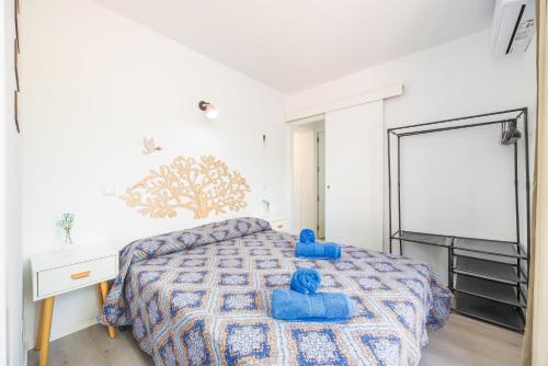 a bedroom with a bed with blue pillows on it at Gran Sol Family 2 in Felanitx