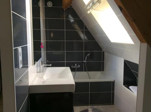 a bathroom with a sink and a bath tub at La Maison Leontine in Cahus