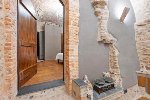 a hallway with a door and a brick wall at Antico Frantoio in Ceriale