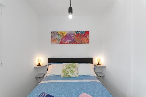 a bedroom with a bed with a painting on the wall at vv Luca vista mar in Puerto Rico de Gran Canaria