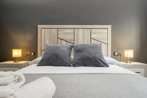 a bedroom with a bed with pillows and two lamps at Kaixo in Calafell