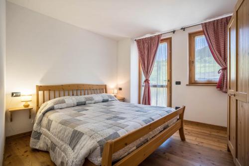a bedroom with a bed and two windows at Agritur piazera con terrazzo in Ronzo Chienis