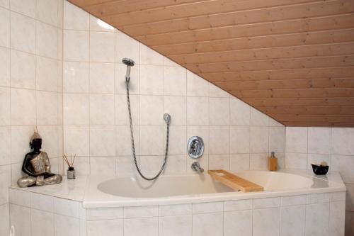 a bath tub with a shower in a bathroom at Wohnung Karin in Spalt
