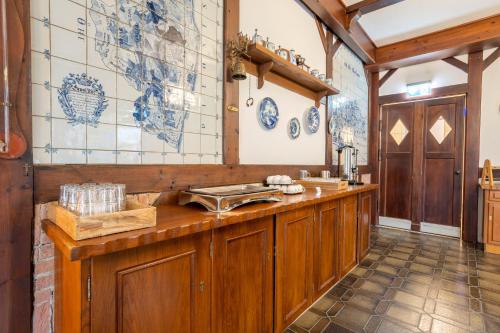 a kitchen with wooden cabinets and blue and white tiles at Landhaus Ostseeblick Fewo 5 - in Kronsgaard