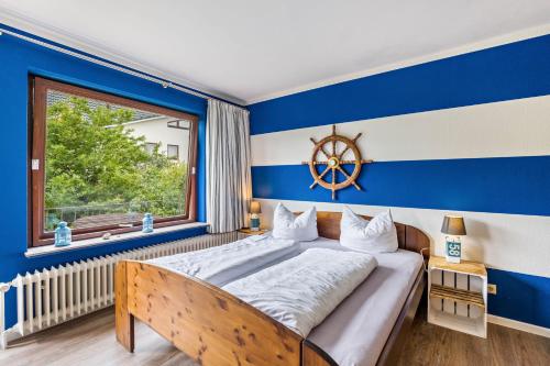 a bedroom with a large bed with a blue wall at Landhaus Ostseeblick Fewo 5 - in Kronsgaard