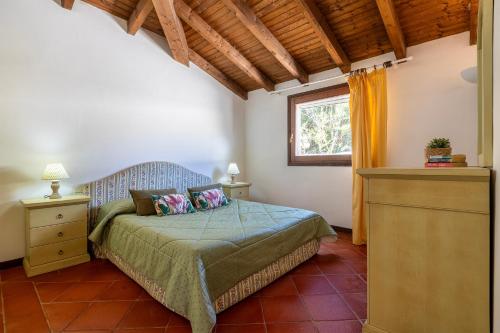 a bedroom with a bed and a window at Villa Sabbia - Private pool in Stintino