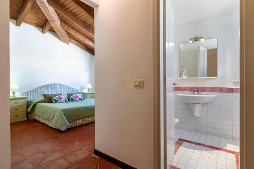 a bathroom with a bed and a sink in a room at Villa Sabbia - Private pool in Stintino