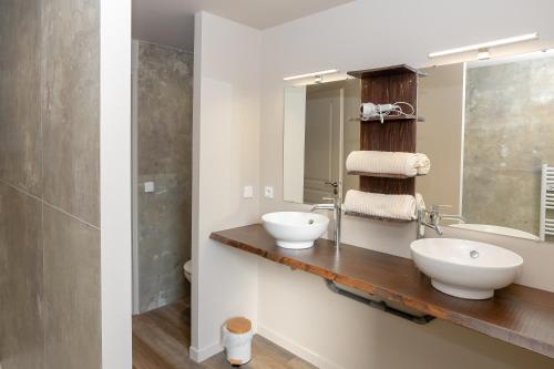 a bathroom with two sinks and a mirror at Gite La Maison Du Soyeux Ga in Les Abrets en Dauphine
