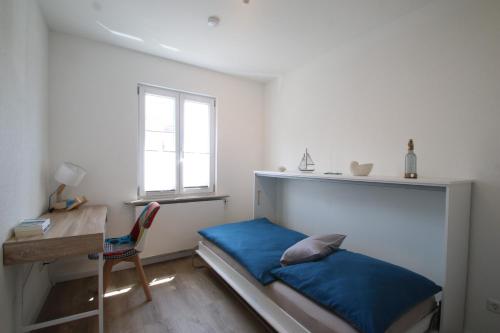 a bedroom with a bed and a desk and a window at Ferienwohnung am Stadtwall in Stockach