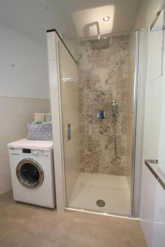 a shower in a bathroom with a washing machine at Ferienwohnung am Stadtwall in Stockach
