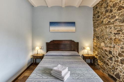 a bedroom with a bed with two lamps on two tables at Casa Rural El Torn in Garriguella