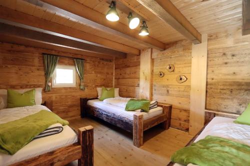 a log cabin bedroom with two beds and a window at Ferienhütte Biobetrieb Lippenhof in Bruckbach