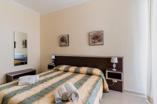 a bedroom with a large bed with two towels on it at Palazzo Mongiò in Gallipoli