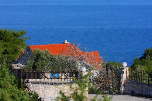 a house with an orange roof next to the ocean at Holiday Home Olea - Sun, Sea, Sport & Comfort in Splitska