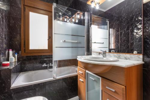 a bathroom with a sink and a tub and a shower at Casa Guadalmar in Málaga
