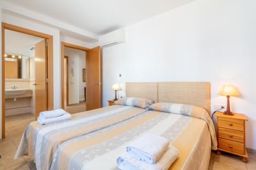 a bedroom with a large bed with towels on it at Talaia 1a in Port de Pollensa