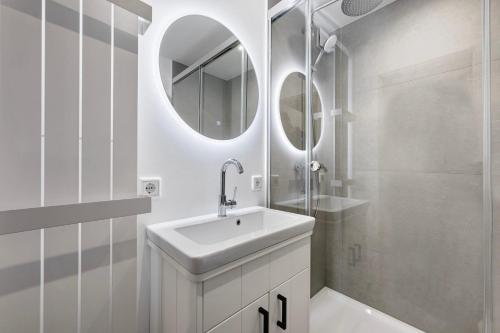 a white bathroom with a sink and a shower at Wohnung Früger in Westerland