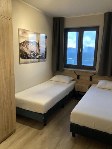 a hotel room with two beds and a window at Wellness Appartement Winterberg E2 in Winterberg