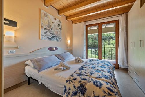a bedroom with a bed and a large window at Residence Tatiana B2 in Tremosine Sul Garda