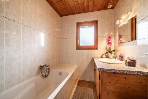 a bathroom with a tub and a sink and a bath tub at Chalet 3 Etoiles - Le pèlouêt in Morzine