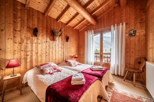 a bedroom with a bed in a room with wooden walls at Chalet 3 Etoiles - Le pèlouêt in Morzine