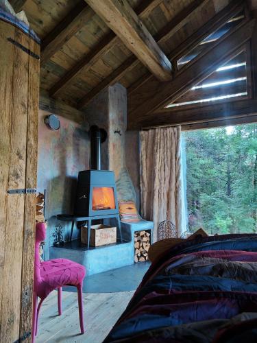 a bedroom with a woodburning stove in a cabin at Chalet Atmosfera Res Albert in San Guglielmo