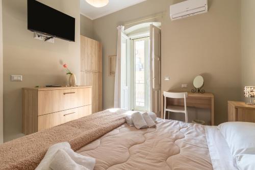 a bedroom with a large bed with a tv on the wall at Dormiamoci Sù in Mottola