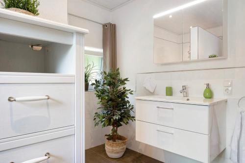 a white bathroom with a sink and a mirror at Ferienhaus Thomas in Colnrade