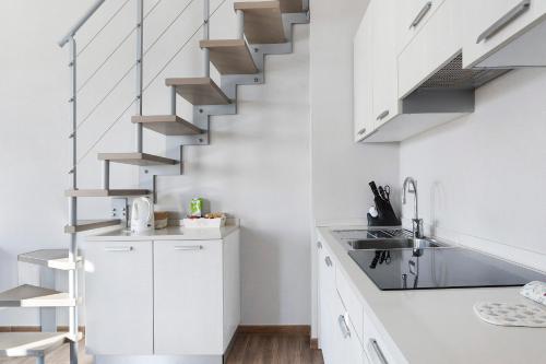 a kitchen with white cabinets and a spiral staircase at Residenza del Capitano in Levanto