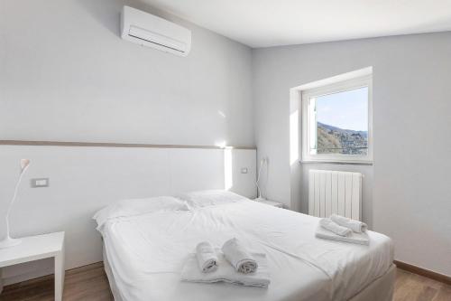 a white bedroom with a bed and a window at Residenza del Capitano in Levanto