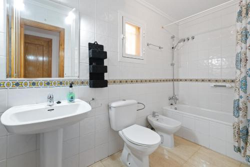 a white bathroom with a toilet and a sink at Casa Max in Gran Alacant